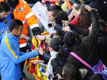 Neymar y Messi firman aut&oacute;grafos a los aficionados.