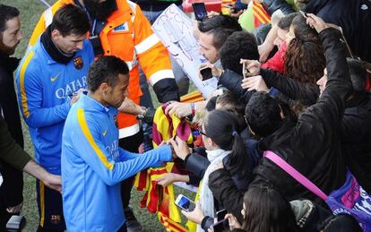 Neymar y Messi firman autógrafos a los aficionados.