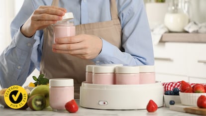 Un hombre preparando yogures de fresa con una yogurtera