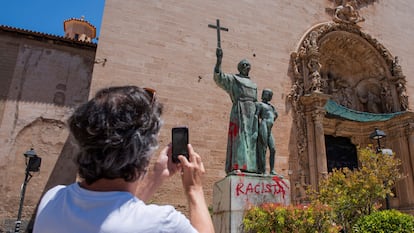 Un hombre fotografía una pintada crítica en el monumento dedicado al fraile Junípero Serra en Palma de Mallorca, el 22 de junio de 2020.