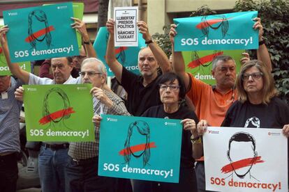 Manifestants amb cartells de protesta davant la seu d'Òmnium per l'empresonament del president de l'ANC, Jordi Sànchez, i el president d'Òmnium Cultural, Jordi Cuixart.