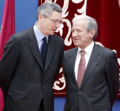 El ministro de Justicia, Alberto Ruiz- Gallardón ( i), conversa con Pascual Sala ( d), presidente del Tribunal Constitucional, en la fiesta de la Comunidad de Madrid.