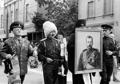 Pie de Foto: Dos soldados (uno de alta graduación), un cosaco y un pope portando un retrato del último zar, en Moscú tras el golpe de estado frustrado de 1991.