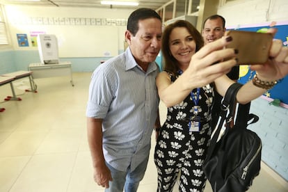 El candidato a la vicepresidencia de Brasil de Jair Bolsonaro, Hamilto Mourao, posa con una simpatizante luego de votar, en Brasilia.