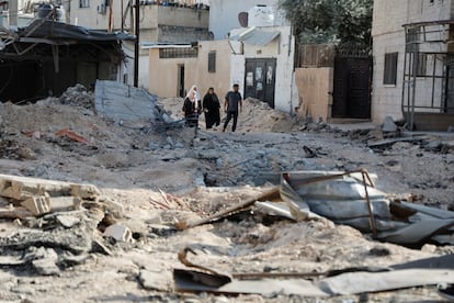 Cuatro palestinos caminaban el viernes entre los escombros tras un ataque israelí al campo de refugiados de Yenín, en la Cisjordania ocupada.