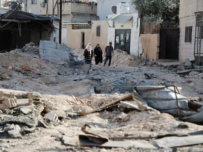 Cuatro palestinos caminaban el viernes entre los escombros tras un ataque israelí al campo de refugiados de Yenín, en la Cisjordania ocupada.