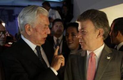 El escritor y premio nobel de literatura Mario Vargas Llosa (i) habla con el presidente de Colombia, Juan Manuel Santos (d), mientras recorren el pabellón de Perú en la la 27 edición de la Feria Internacional del Libro de Bogotá, en Bogotá (Colombia).