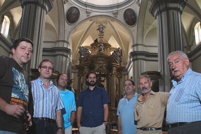 El cura (en el centro) y seis concejales de Burbáguena, en el interior de la iglesia barroca.