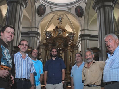 El cura (en el centro) y seis concejales de Burbáguena, en el interior de la iglesia barroca.
