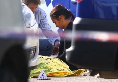 Una mujer llora ante el cuerpo cubierto del hombre muerto en Figueres.