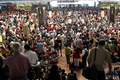 Miles de personas abarrotan las instalaciones del aeropuerto de El Prat de Barcelona a la espera de poder facturar el equipaje y emprender viaje.