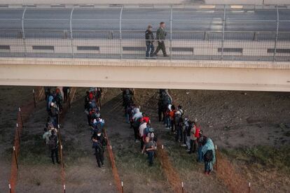 Migrantes esperan subir a un autobús de Aduanas y Protección Fronteriza que sale del lugar donde se encontraba el campamento improvisado a lo largo del Puente Internacional en Del Rio, Texas.