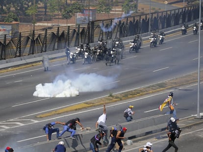 Los opositores de Maduro huyen de las tropas leales al Gobierno, que les han atacado con gas lacrimogeno. 