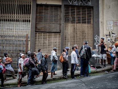 Personas sin techo hacen cola para recibir un plato de comida en una calle de São Paulo (Brasil), el 21 de octubre de 2022.