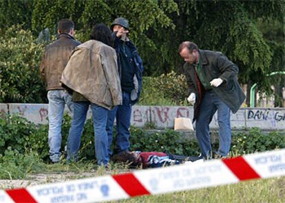 Policías de paisano observan el cadáver de la joven de 17 años que murió degollada en el parque de Pradolongo.