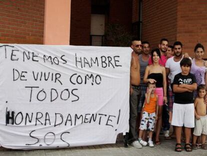 Algunos de los vecinos del barrio de Alfafar frente a las pancartas contra el desalojo. 