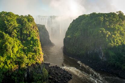 Zambia. Desde nadar en el borde de una cascada hasta ir de safari fotográfico a pie, un viaje por Zambia es una oportunidad para reconectar con la naturaleza y la cultura africana. Aunque sin salida al mar, por su territorio discurren tres grandes ríos ―el Kafue, el Luangwa y el Zambeze― que definen la geografía y el ritmo de vida de sus habitantes. Zambia está llena de cascadas, lagos y parques nacionales. Se puede partir desde Lusaka, la capital, con un encuentro con el arte zambiano más urbano, o visitando el parque nacional Lusaka, el más pequeño de los 20 que tiene el país. La gastronomía en la capital se concentra en los barrios periféricos como Longacres y Rhodes Park, donde es posible sumergirse en la cocina tradicional africana. Pero lo que todos van a ver cuando visitan Zambia son las cataratas Victoria y para eso hay que volar hasta Livingstone. Allí están los espectaculares saltos de agua que sirven de frontera con Zimbabue, y un puente que permite atravesar algunos a pie . Una experiencia mágica es hacer un crucero al atardecer por el río Zambeze, entre hipopótamos y elefantes, o hacer un safari por el parque nacional Mosi-oa-Tunya. Pero la mejor zona natural protegida probablemente sea el parque nacional South Luangwa, en Mfuwe, en el este del país. Por su paisaje, variedad y densidad de población animal, accesibilidad y oferta de alojamiento. Por sus amplias llanuras deambulan impalas, antílopes, jirafas y búfalos; los numerosos leopardos cazan en los tupidos bosques; las manadas de elefantes recorren los pantanos y los hipopótamos comen apaciblemente en el río Luangwa.