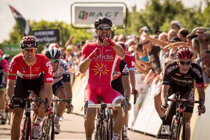 Bouhanni, en el centro, lanza sus pu&ntilde;os al ganar la etapa.