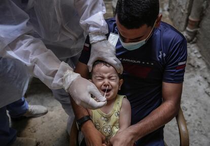 Un médico palestino toma muestras para las pruebas de coronavirus a un niño en la ciudad de Beit Hanun. La pequeña ciudad, en el norte de Gaza y bajo bloqueo israelí desde hace 13 años, tiene el mayor índice de casos de covid del enclave.