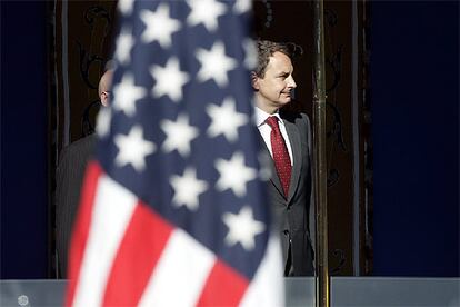 Zapatero contempla de pie el paso de la bandera de EE UU durante el desfile de la Fiesta Nacional.