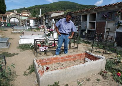 Yash Paul Gosain, bisnieto de Pilar Espinosa Camacho, observa el nicho en el que estaba enterrada su bisabuela hasta el pasado 29 de julio. A sus pies, la tumba de la madre del alcalde de Poyales del Hoyo, que ordenó la exhumación; al fondo a la derecha, la fosa común donde fueron trasladados los restos.