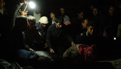 Un grupo de ciudadanos busca supervivientes entre los escombros causados por un ataque con misiles Scud en Tariq al-Bab, Alepo.