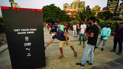 Ciudadanos indios acuden al dispensador de mascarillas que LaLiga colocó en Bombay.