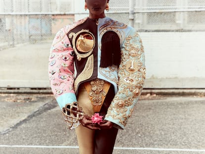 Chaqueta entallada bordada con brazos oversize y realizada en seda. Las técnicas de bordado están inspiradas en los archivos de Schiaparelli Sombrero metalizado en forma de cúpula con forro de satén acolchado en rosa. Zapatos de satén negro con lazos de seda adornados con puntas doradas con uñas plateadas.