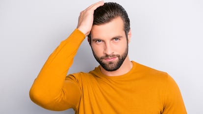 Un hombre mostrando su peinado sobre un fondo neutro.