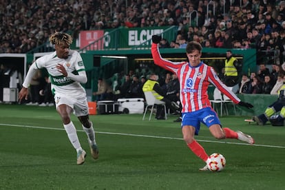 El centrocampista del Atlético de Madrid, Rodrigo Riquelme (d), con el balón ante el defensa del Elche, John Donald, durante el encuentro de octavos de la Copa del Rey este miércoles.