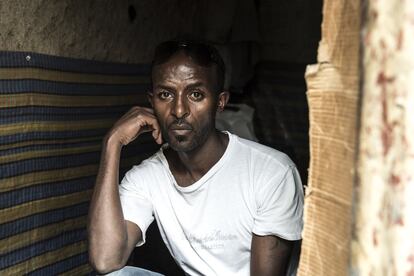 Freu, de 32 años, en la entrada de la cabaña de tierra, paja y chapa donde vive con un amigo. Está esperando por el visado. “La vida aquí en Addis Abeba es mejor que la nuestra, pero no es fácil llegar a ganar algún dinero. Yo quiero irme, quiero probar suerte y vivir como vosotros los occidentales”.