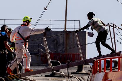 Un miembro de Salvamento ayuda a una de las personas migrantes, a su llegada al puerto de La Estaca, este martes.