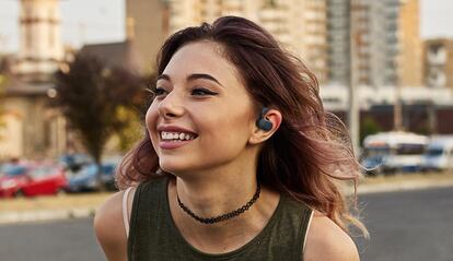 Chica utilizando los auriculares Creative Outlier Go