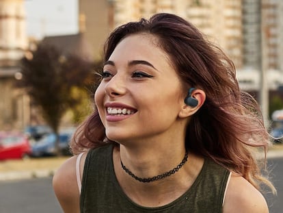 Chica utilizando los auriculares Creative Outlier Go