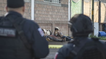Dos agentes de policía miran los cadáveres de cinco hombres encontrados asesinados a balazos en una calle de Culiacán, en Sinaloa (México).