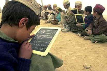 Un grupo de niños refugiados afganos en Pakistán practica caligrafía arábiga en sus pizarras.