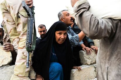 Varias personas que han sido desplazadas debido a la operación de las fuerzas iraquíes contra los yihadistas, esperan para recibir comida cerca de Qayyarah.