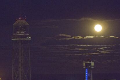 La Superluna fotografiada en barceona contras las torres del teleférico del puerto.