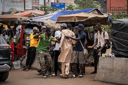 Mamadou junto a los jóvenes del barrio, donde le invitan un café y un bocadillo por la mañana en Dakar el 6 de julio.