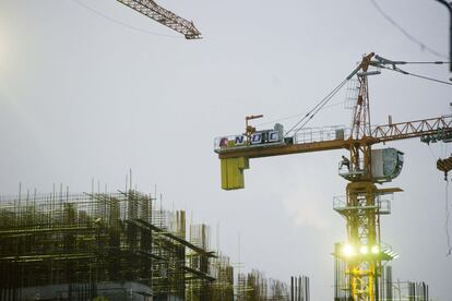 Un obrero trabaja sobre una grúa en una obra en construcción en el centro de Yangon.