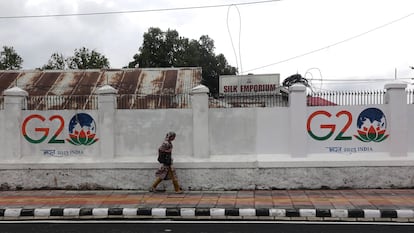 Una mujer pasa junto a un muro con pintadas del G20 en Srinagar, en la Cachemira india, el 24 de mayo de 2023.