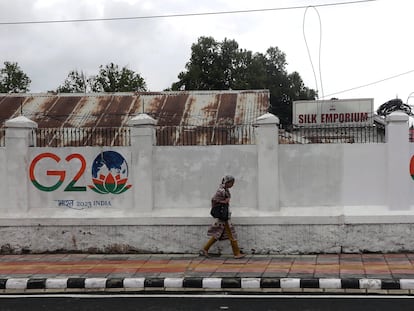 Una mujer pasa junto a un muro con pintadas del G20 en Srinagar, en la Cachemira india, el 24 de mayo de 2023.