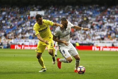 El jugador del Real Madrid, Karim Benzema disputa el balón con el jugador del Villareal, Mario Gaspar Pérez.