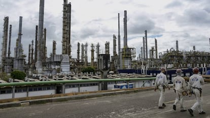 Trabalhadores passeiam diante da indústria petroquímica em Camaçari, no Brasil