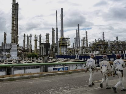 Trabalhadores passeiam diante da indústria petroquímica em Camaçari, no Brasil