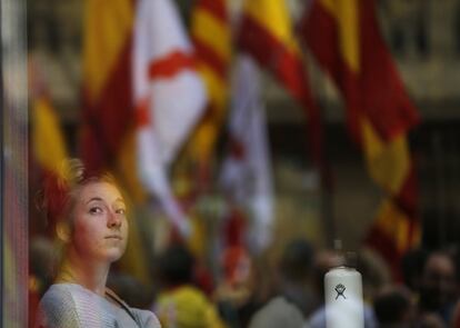 Una jove observa la manifestació des d'un establiment.