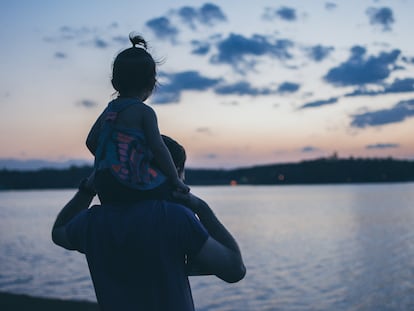 Un padre aúpa a su hijo en los hombros.