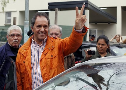 Daniel Scioli, gobernador y candidato presidencial, hace la señal de victoria, después de emitir su voto.