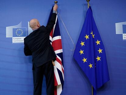 Un empleado coloca las banderas del Reino Unido y de la Unión Europea en la sede de la Comisión en Bruselas.
