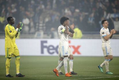 El arquero de Olympique Steve Mandanda (i) y Luiz Gustavo (c) salen del campo.